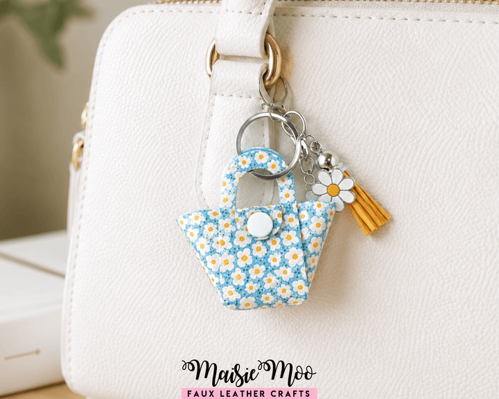 Teeny Tiny Tote Bag Charm in blue floral design attached to a handbag, perfect for adding a cute touch. Tote Bag Charm.