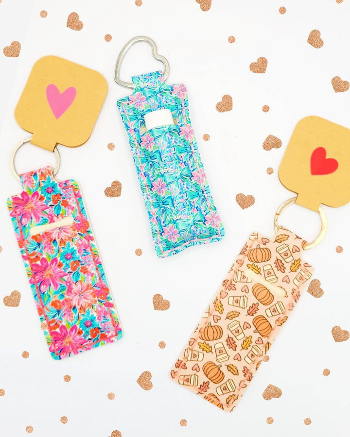 Colorful Chapstick Holder Pattern keychains featuring floral and themed designs with heart-shaped tags.