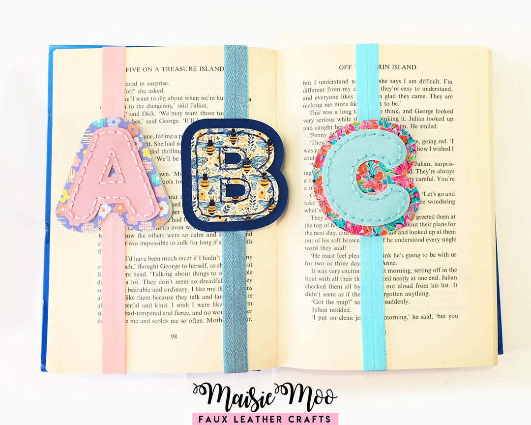 Alphabet Bookmark SVG Set for Cricut featuring stitched initial bookmarks A, B, C on an open book.