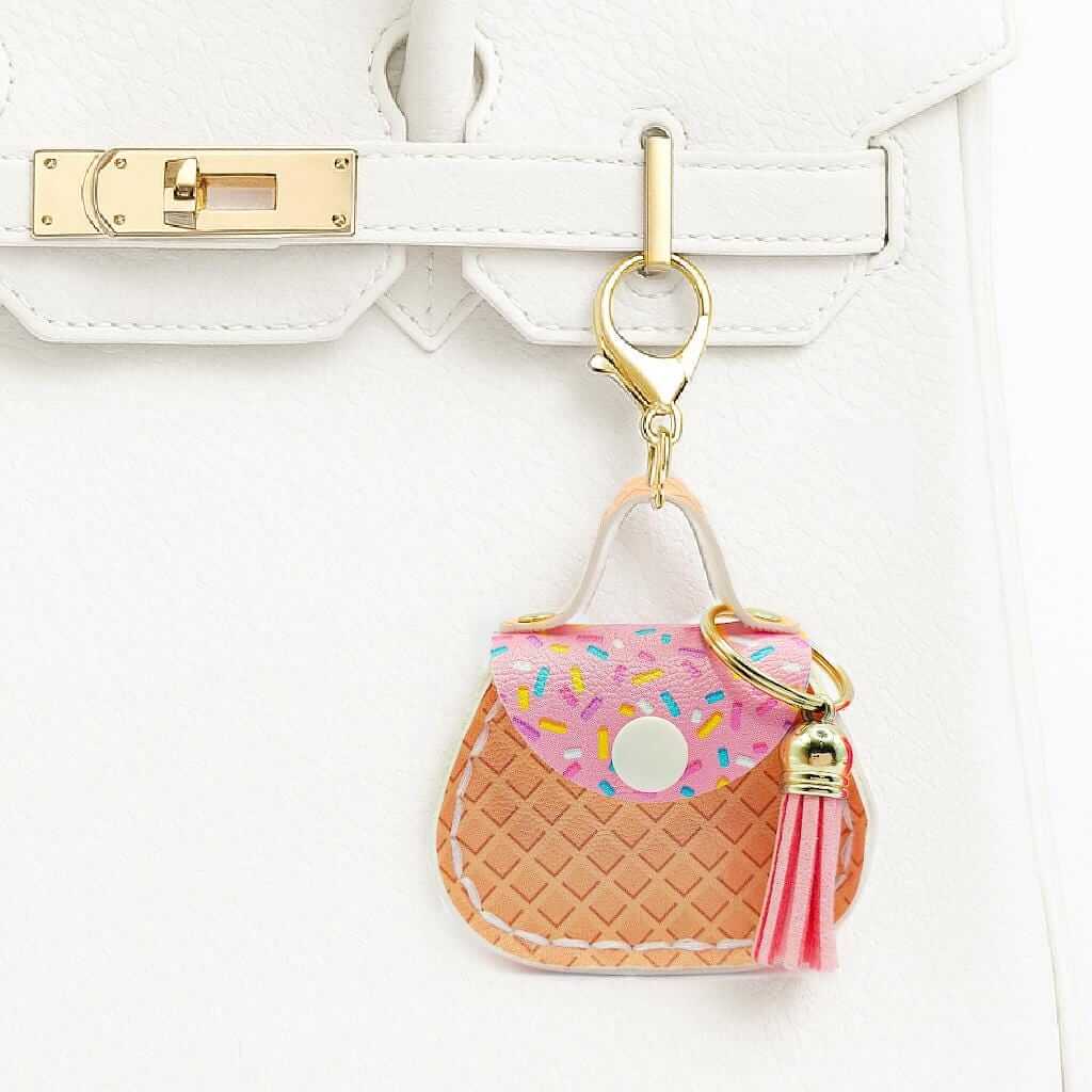 Mini Round Purse Bag Charm attached to a handbag, featuring faux leather and colorful design elements.